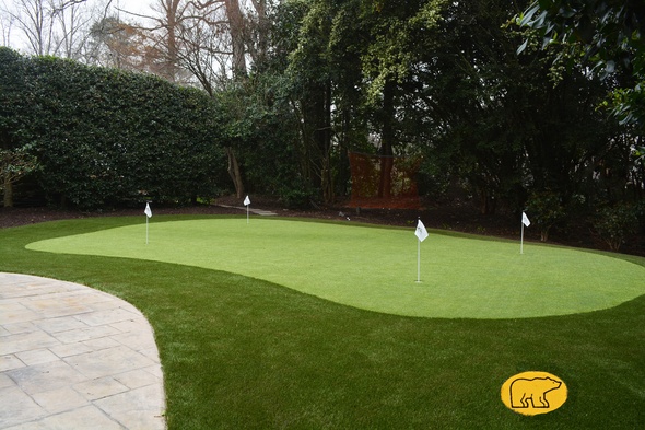 Phoenix Synthetic grass golf green with 4 holes and flags in a landscaped backyard