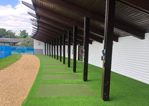 Phoenix Covered outdoor tee line with light green synthetic grass boxes inside a dark green synthetic grass strip