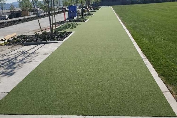 Phoenix Outdoor tee line consisting of one continuous green synthetic grass strip surrounded by trees